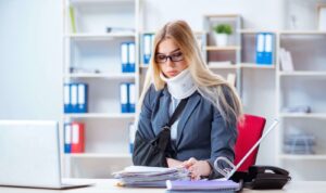 Girl with a cast on her arm and neck in the office