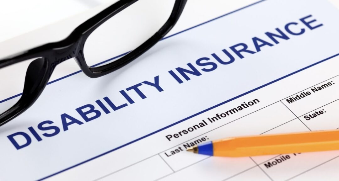 Disability insurance form with pen and glasses